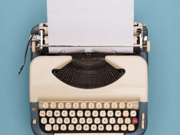 Aerial view of a white typewriter on a blue background